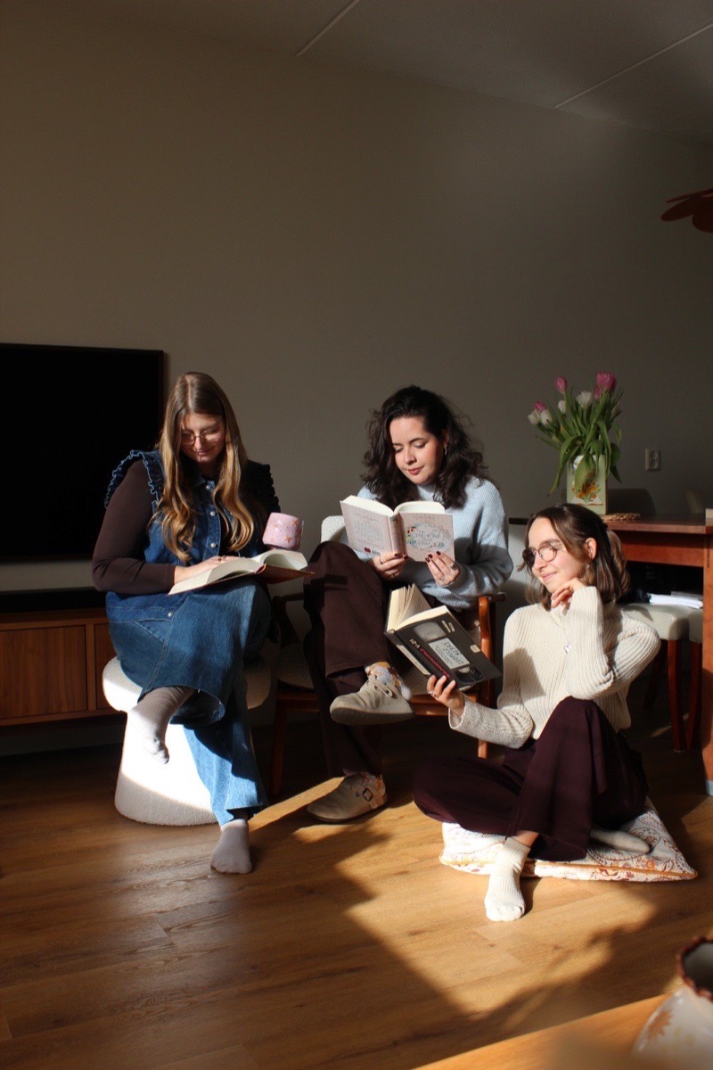 Claire, Nicole en Vera lezen samen op de grond